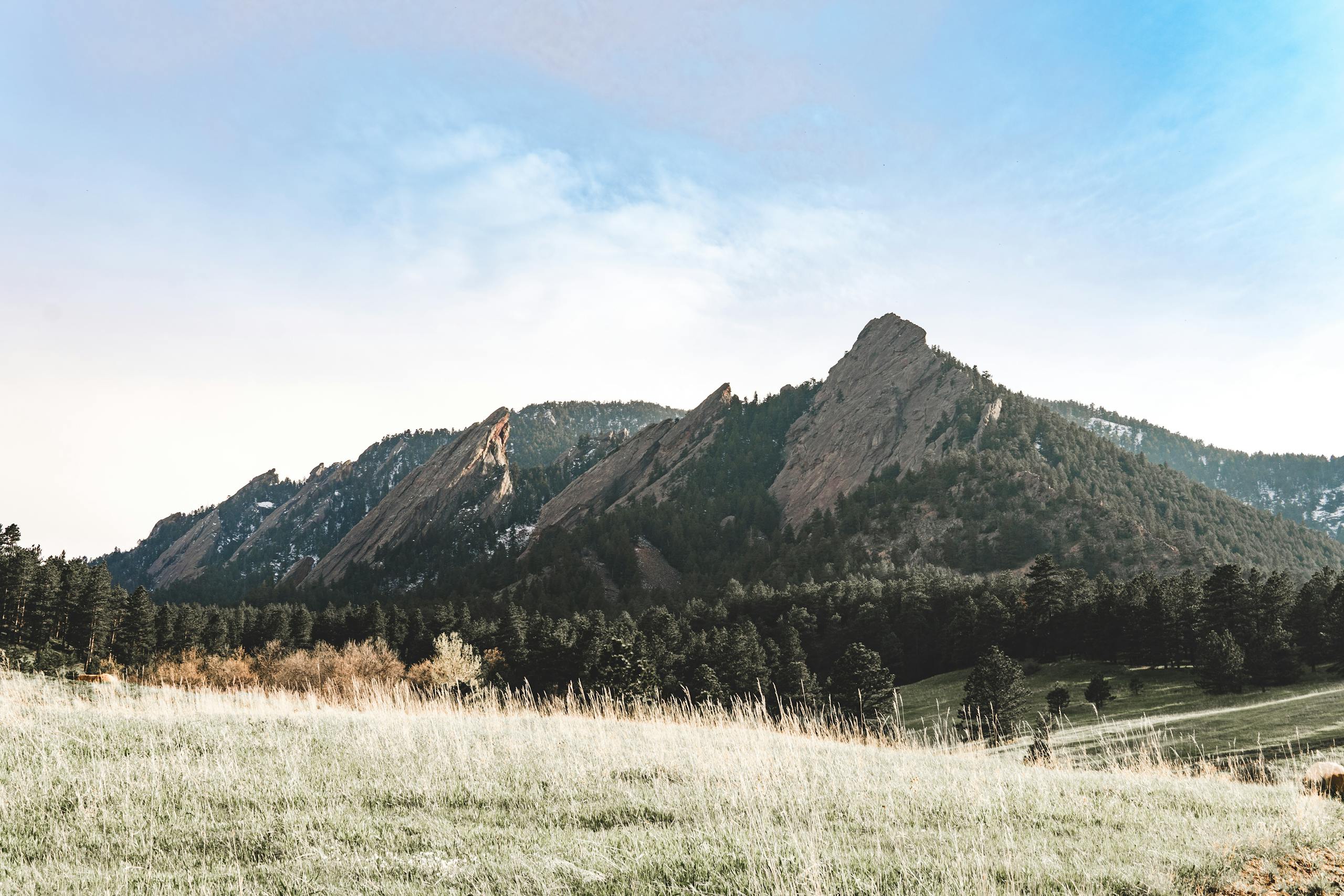 A breathtaking view of the picturesque Flatirons mountains in a serene landscape.