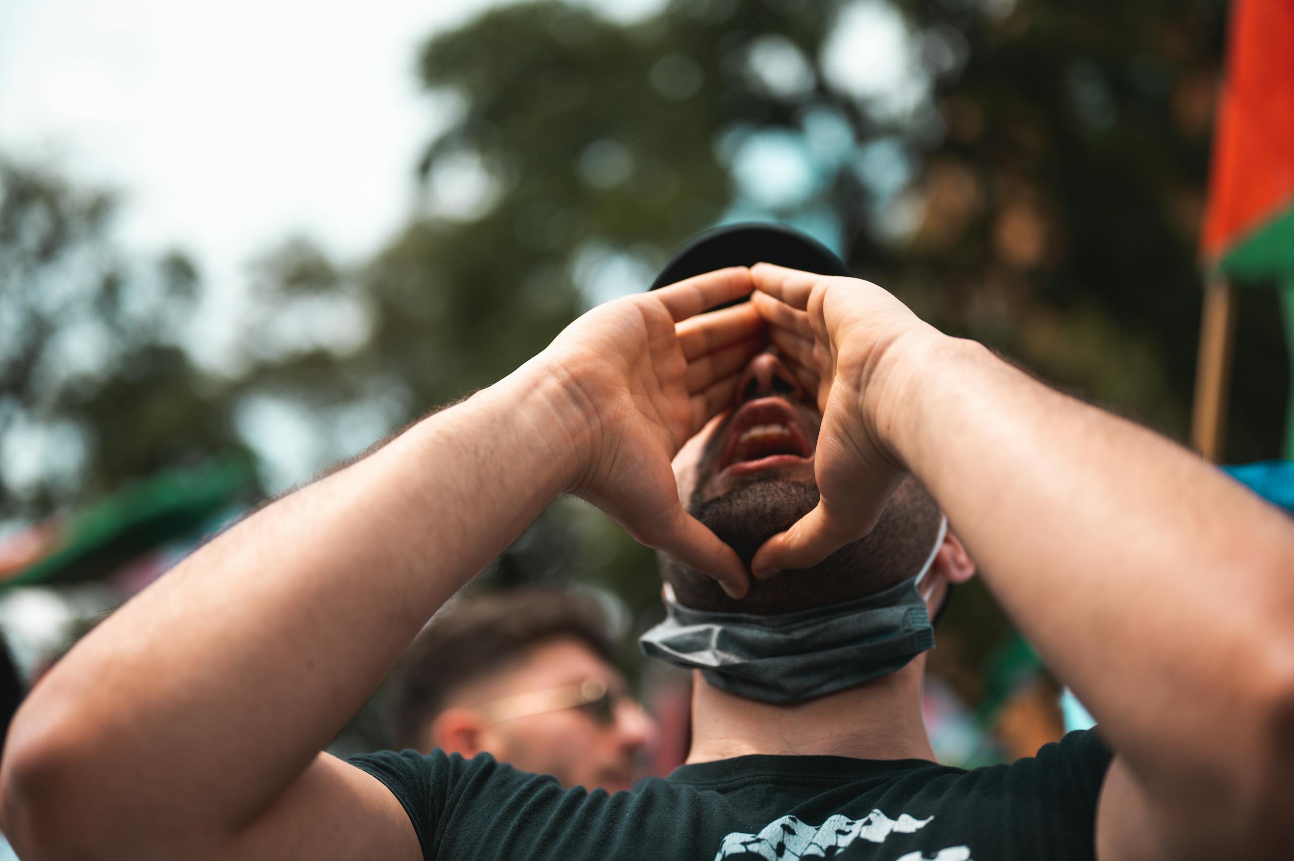 Man passionately shouting during an outdoor protest, capturing activism and engagement.