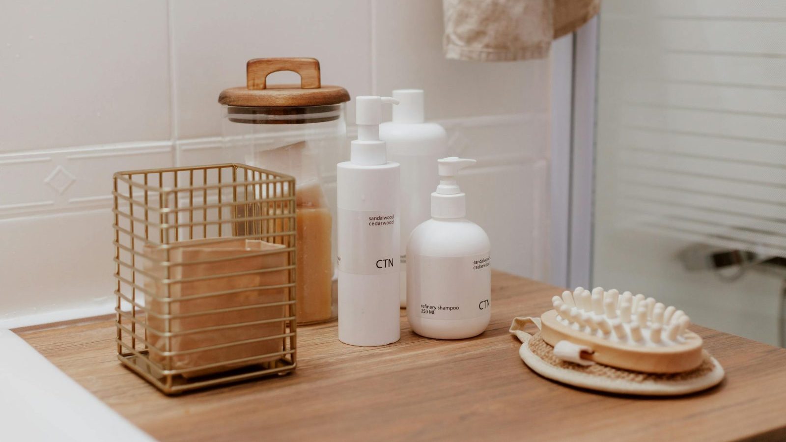 Stylish bathroom arrangement featuring cosmetic bottles and toiletries on a wooden surface.