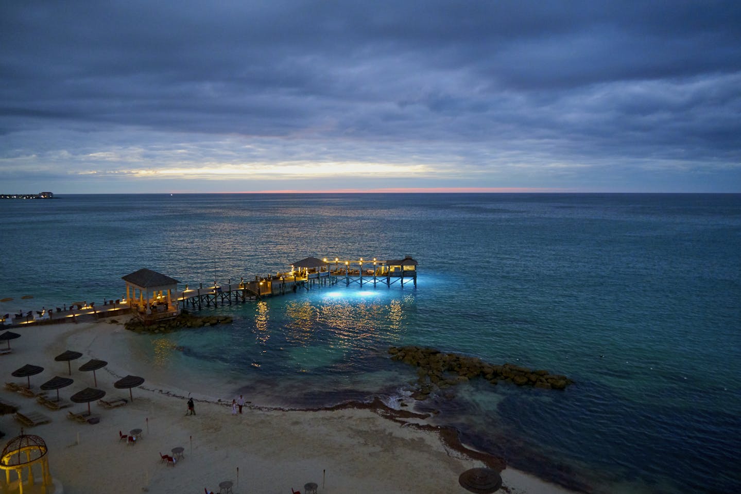 Twilight envelops the serene beach and pier in Nassau, The Bahamas, with stunning seascape views.