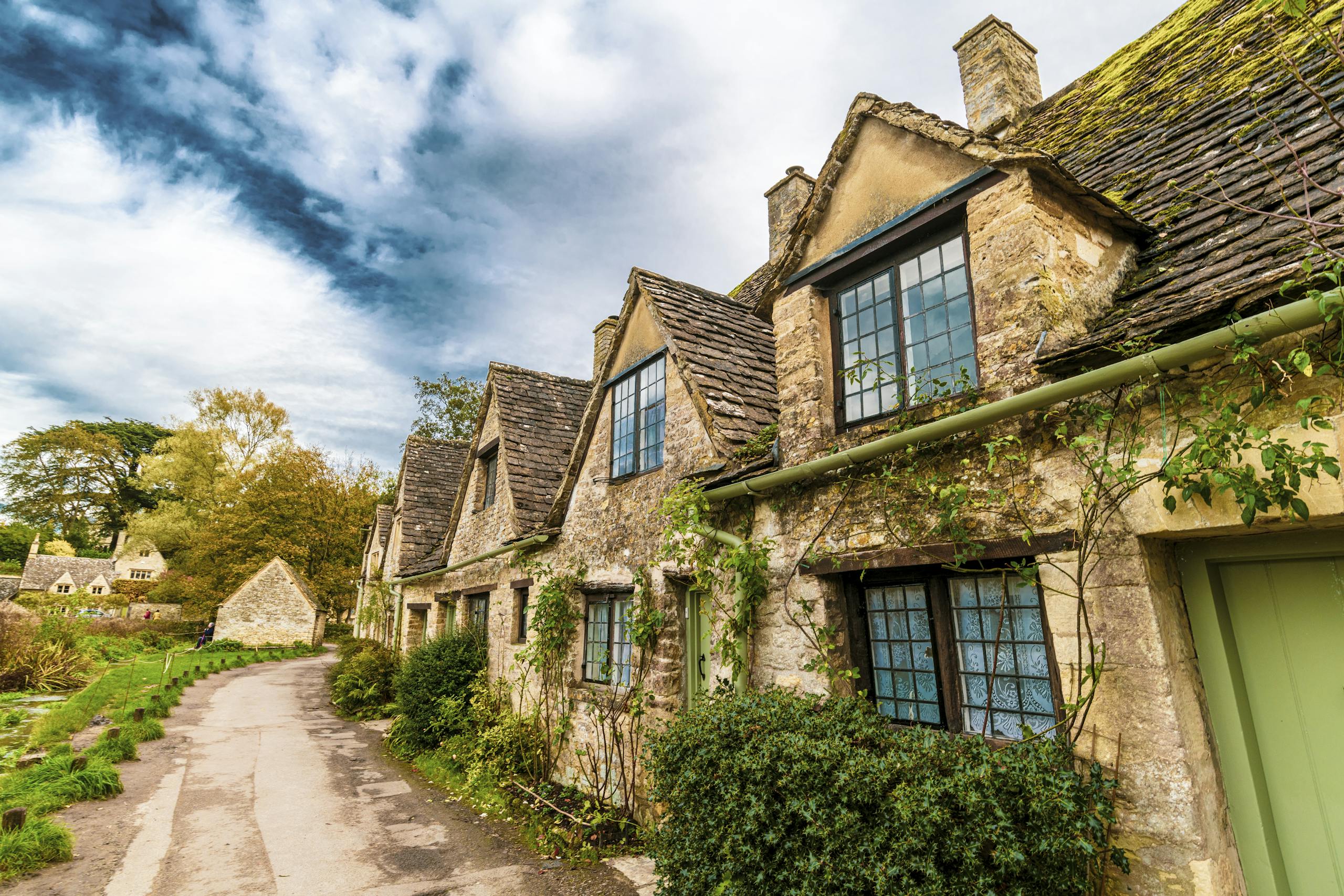 Charming old cottages line a picturesque street in Bibury, England.