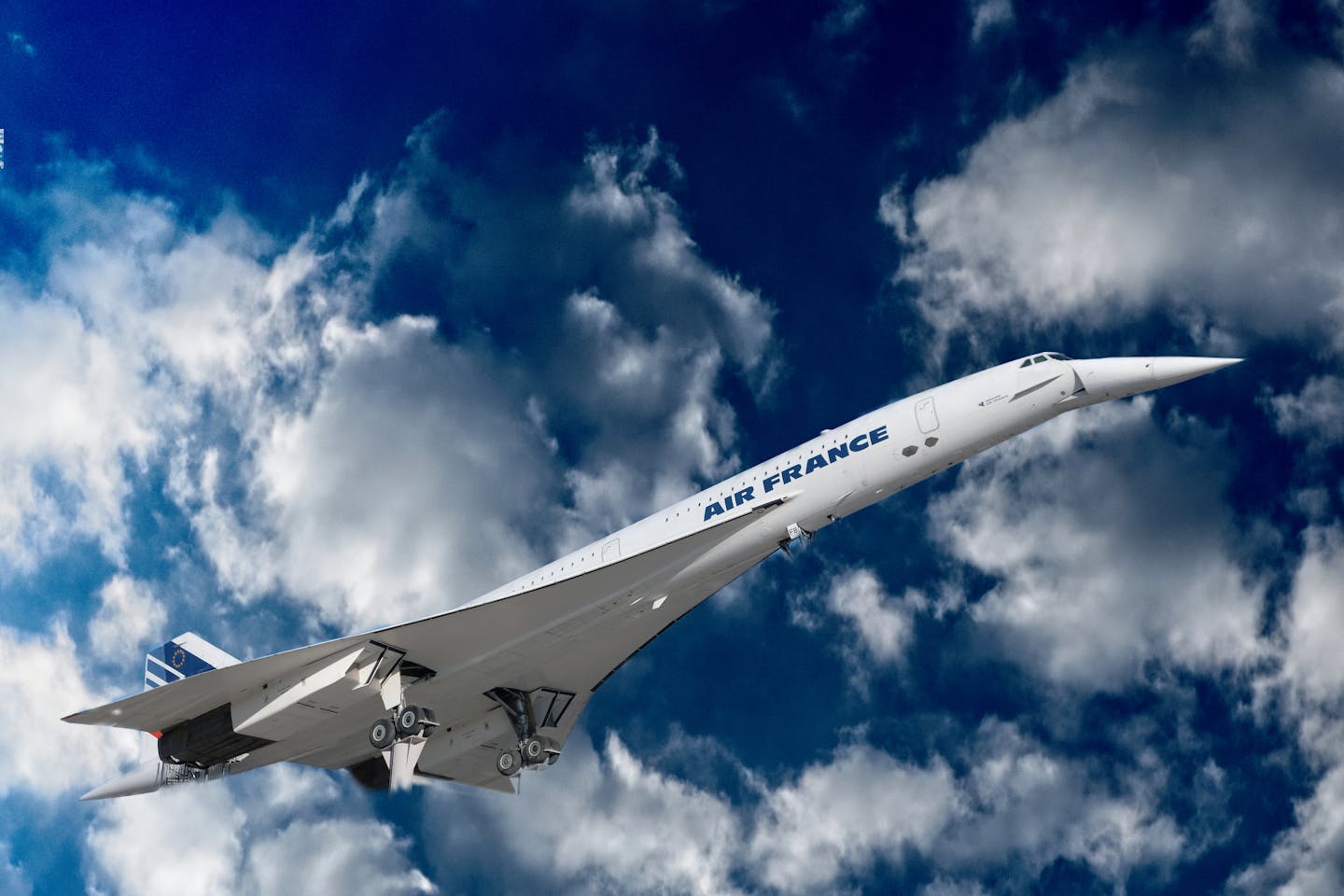 A stunning view of the Concorde aircraft soaring through a blue sky filled with clouds.