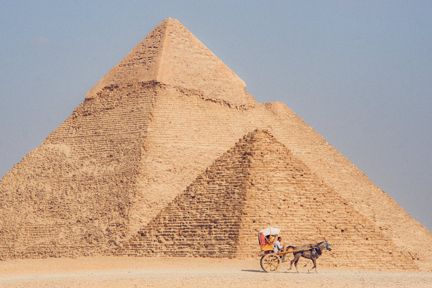 Iconic Giza Pyramid in Egypt with a donkey cart. Perfect travel and cultural heritage image.