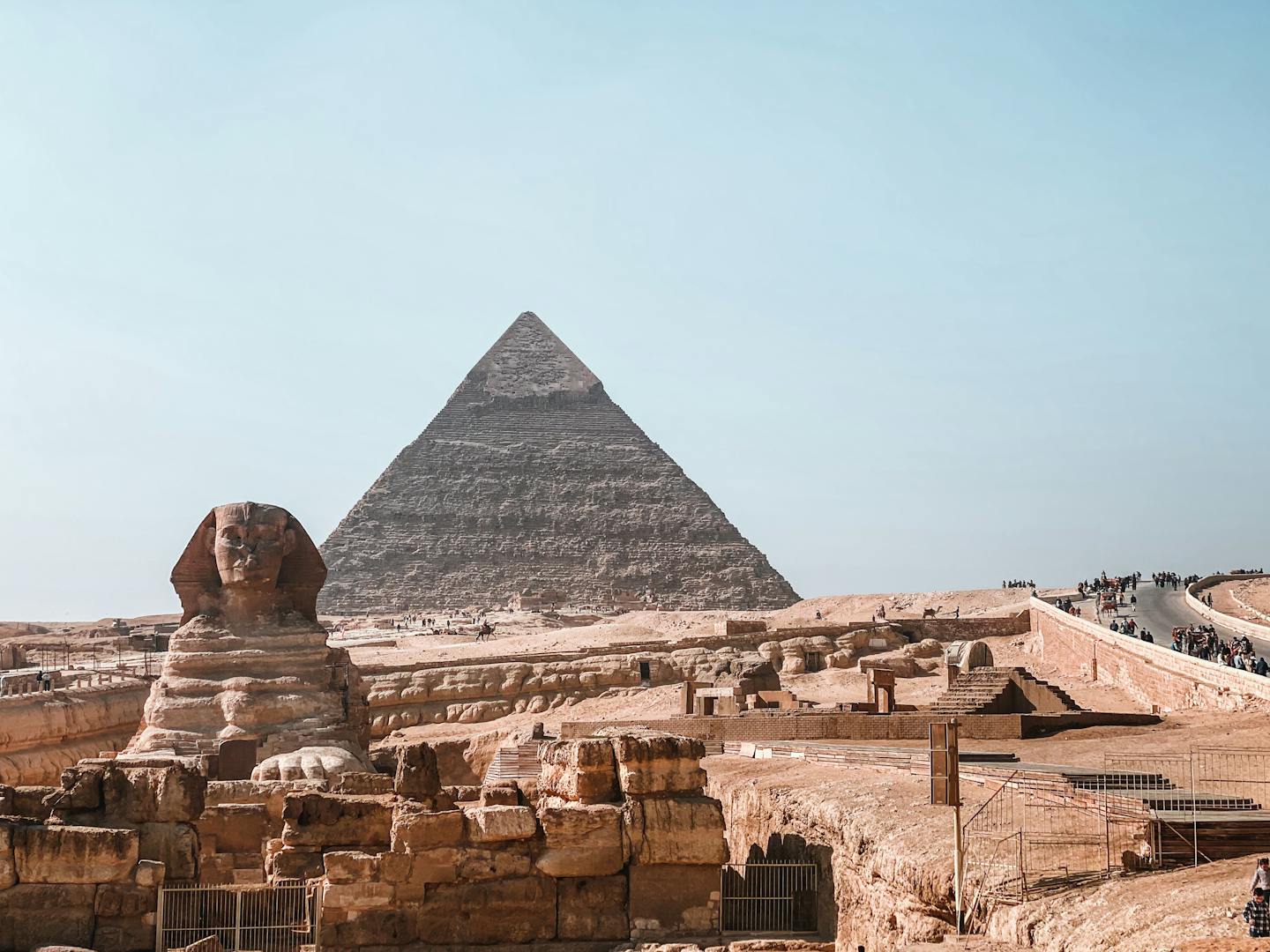 View of the Great Sphinx and Pyramid of Giza on a clear day, capturing ancient Egypt's iconic landmarks.