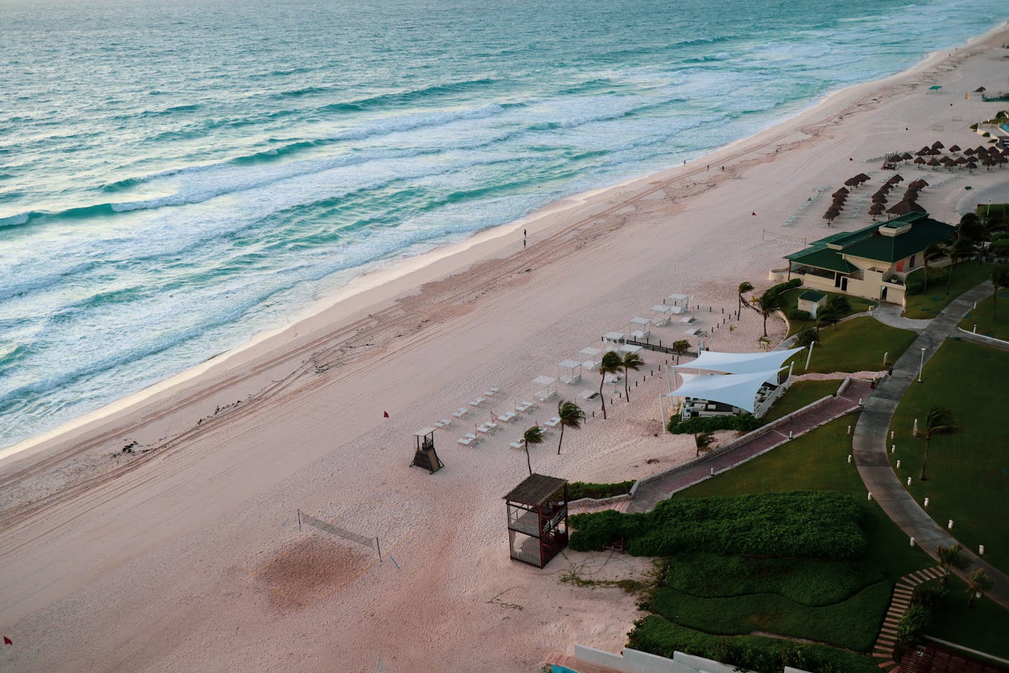 Serene aerial view of Cancun's beautiful beachfront with turquoise waters and sandy shores.